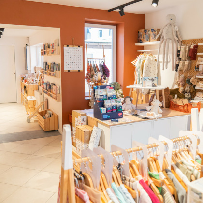 Intérieur du magasin de vêtements pour enfants et bébés à Herve Mai Minus présentant les différentes gammes