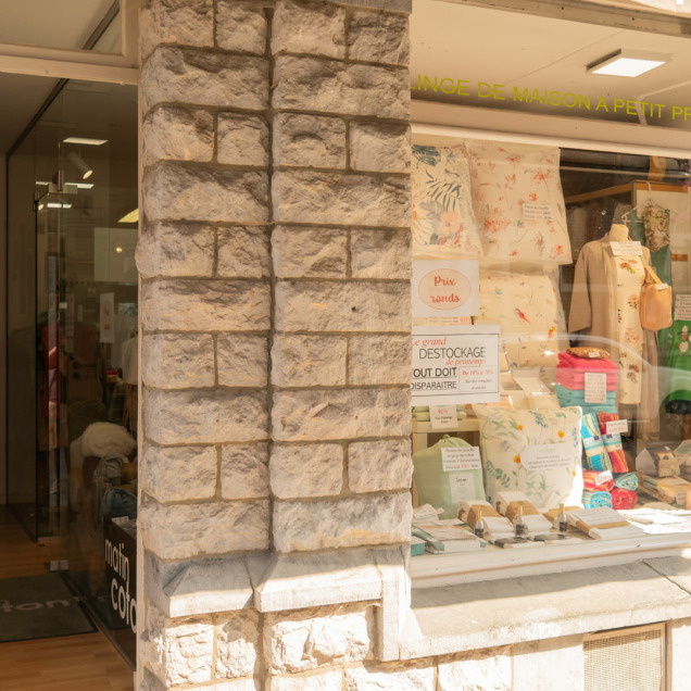 Vitrine du magasin Matin Coton à Visé, présentant des articles de linge de maison et des affiches de soldes pour le déstockage de fin de saison.