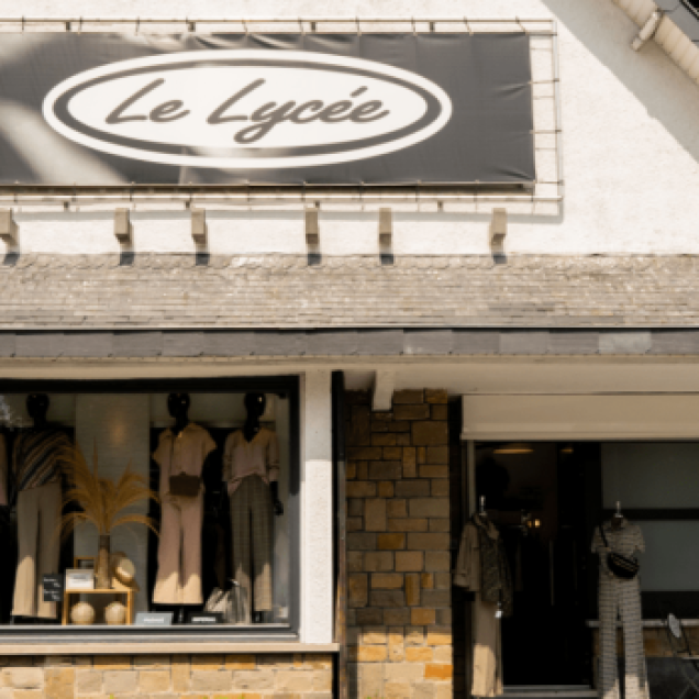 Devanture du magasin "Boutique Le Lycée" à Neupré, avec une vitrine qui expose divers articles de mode.