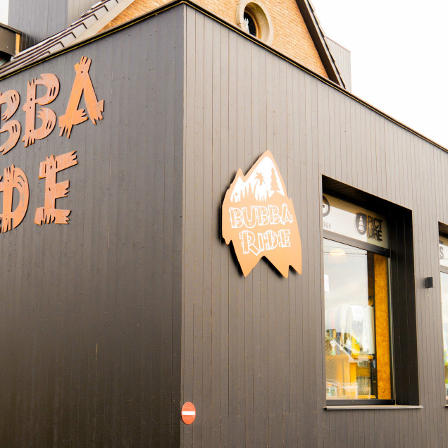 Devanture du magasin “Bubba Ride” à Liège  avec le nom en grandes lettres orange. Il y a une vitrine avec des articles exposés et une porte ouverte à droite.