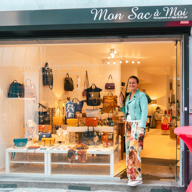 Devanture du magasin “Mon Sac à Moi” à Liège. La vitrine expose divers sacs et accessoires, éclairés par une lumière intérieure vive. Un mannequin vêtu de vêtements colorés se trouve d’un côté de la vitrine.