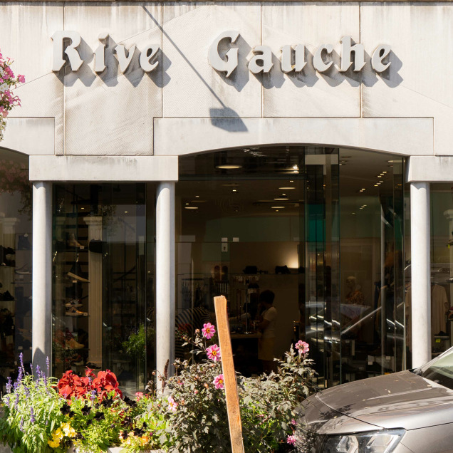 Devanture du magasin “Rive Gauche” à Visé, on peut voir des arrangements floraux et divers articles à travers les vitrines, suggérant qu’il s’agit peut-être d’une boutique ou d’un magasin de cadeaux.