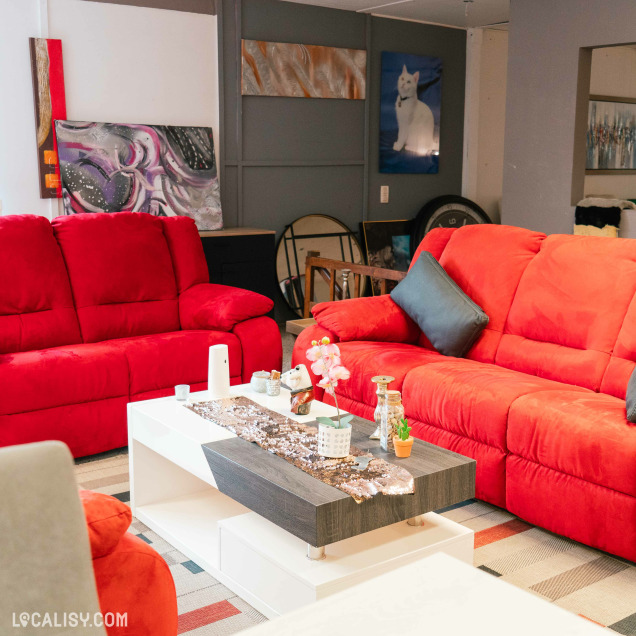 Salon chez Meubles Family à Hannut, avec des canapés rouges, une table basse moderne et une décoration accueillante.