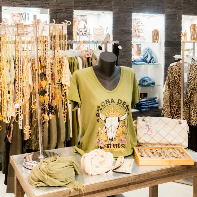 Vêtements, sacs à main, bijoux et accessoires exposés dans un décor moderne dans le magasin "Boutique Le Lycée" à Neupré.