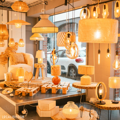 L’intérieur du magasin “Lamp SPRL” à Liège avec divers styles de lampes et luminaires allumés sont exposés, créant une ambiance chaleureuse.