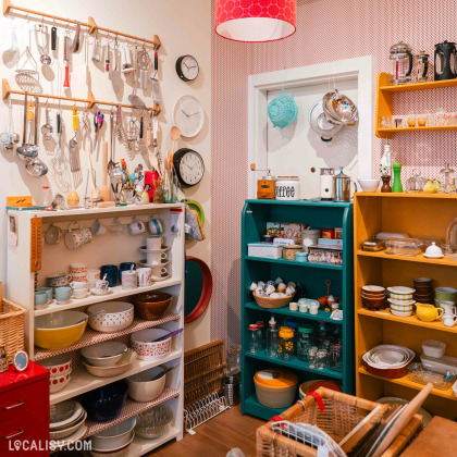 Intérieur du magasin “Ma maison bien-aimée” à Liège bien organisé et propose divers articles pour la maison, tels que des bols, des assiettes, des tasses, des ustensiles et des horloges.