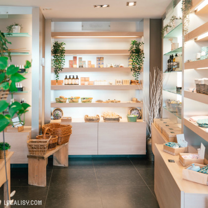 Le magasin “Stilla Oleum” à Liège a une esthétique moderne et naturelle avec des étagères en bois remplies de produits, probablement des huiles ou des cosmétiques naturels. Des plantes vertes ajoutent une touche de nature à la décoration, créant une atmosphère accueillante et apaisante.