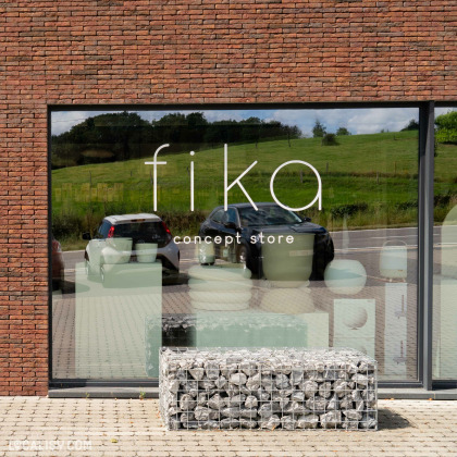 Façade vitrée du Fika concept store à Aubel avec vue sur la campagne.