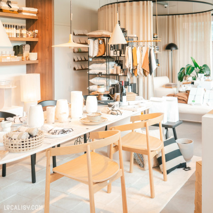 Ambiance conviviale au Fika Concept Store à Aubel, avec une table, deux chaises et des lampes design qui illuminent l'espace