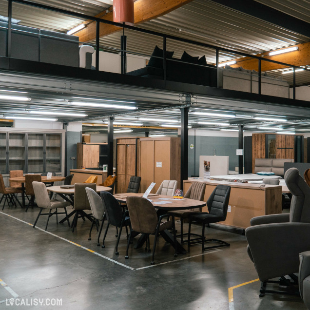 La section salle à manger de Destock Meubles à Seraing présente des tables, chaises et meubles de rangement exposés dans un vaste espace.