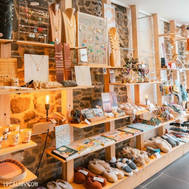 Des étagères bien organisées exposant divers articles de bijoux, accessoires et objets de décoration au magasin “Orangeola by Math” à Tilff.