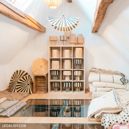 L’intérieur du magasin “Le Cottage Interior” à Charneux, avec une conception rustique et chaleureuse, des poutres en bois apparentes, et divers articles de décoration.