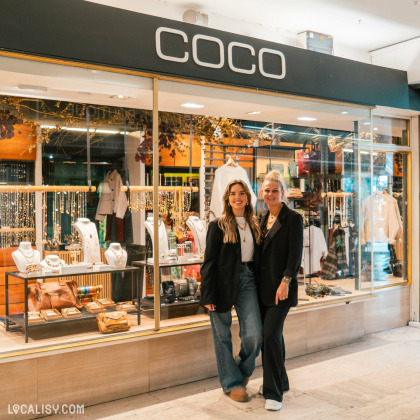 Devanture du magasin “Coco Bijoux et Accessoires” à Liège, avec deux personnes debout devant. Des bijoux et accessoires exposés dans la vitrine.