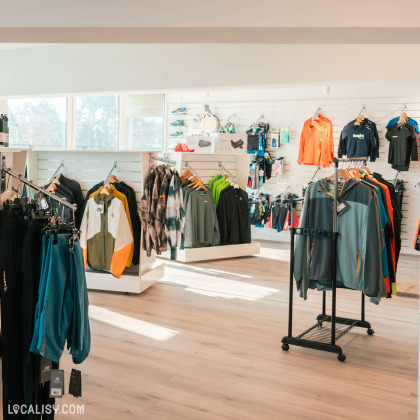 Divers vêtements de sport soigneusement exposés sur des portants et des étagères à l’intérieur du magasin “Respire Sports” à Jalhay.