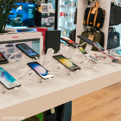 L’intérieur du magasin “DGS Informatique” à Saint-Georges-sur-Meuse, avec divers smartphones et accessoires exposés.