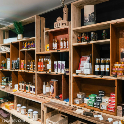 Étagères en bois contenant des produits de soins, cosmétiques et savons artisanaux, décorées avec des éléments culturels et naturels, dans une boutique à l’ambiance authentique.