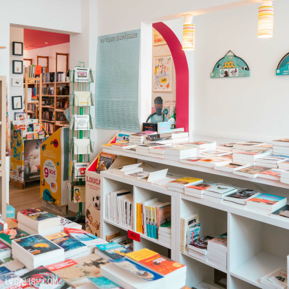 Intérieur de la ''Librairie Long-Courrier'' à Tilff avec des étagères remplies de livres, jeux, puzzles et bricolages d'enfants