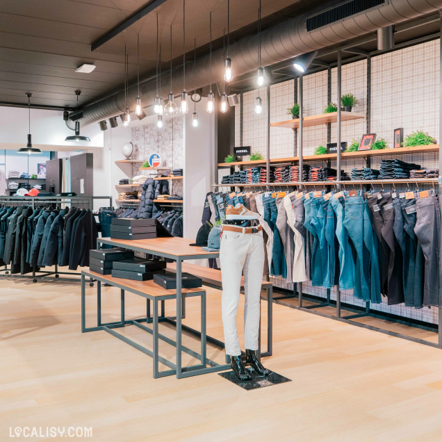 Un présentoir de vêtements pour hommes dans le magasin de vêtements pour hommes Thimister Men à Herve. On peut y voir une série de jeans et de vestes homme.