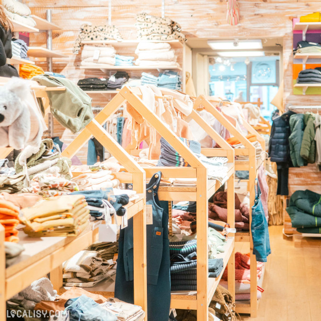 Portants de vêtements colorés au magasin Ma-au Kids à Spa.