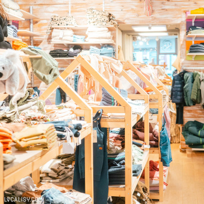 Portants de vêtements colorés au magasin Ma-au Kids à Spa.