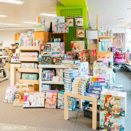 L'intérieur du magasin de produits d'occasion Toup'tibou à Waimes, avec plusieurs étagères et tables remplies de boîtes de jeux et de jouets pour enfants. Les produits incluent des kits de bricolage, des puzzles, des jeux éducatifs et des jouets créatifs. Les étagères sont bien organisées avec une variété de produits colorés, ce qui rend l'endroit attrayant pour les enfants et les parents.