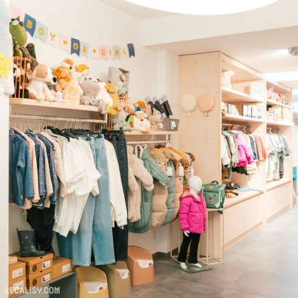 Rayons de vêtements et jouets pour enfants dans la boutique La Marionette à Welkenraedt.