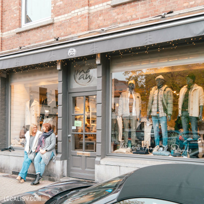 Extérieur du magasin Ma-au à Spa avec mannequins en vitrine et deux clientes devant l’entrée.