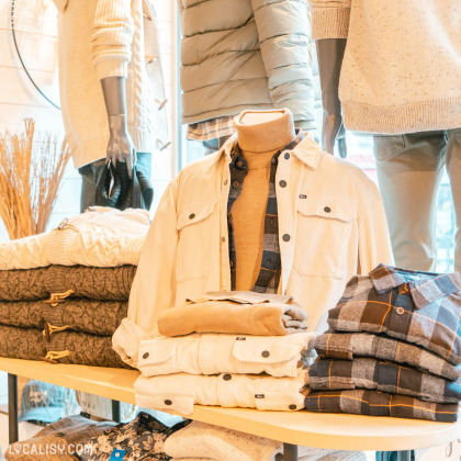 Intérieur du magasin Ma-au à Spa avec des vestes, manteaux et accessoires d’hiver pour femme.