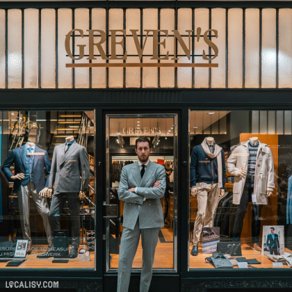 Façade du magasin de vêtements Greven's à Liège avec mannequins en costumes.