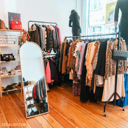 Intérieur du magasin de seconde main à Spa avec vêtements et accessoires pour femmes.