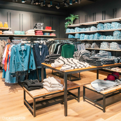 Rayons de vêtements pour femmes au Diabolo Megastore à Fléron, avec jeans, vestes et accessoires.