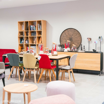 Mobilier moderne et coloré dans le magasin Chez Moi, Meubles et Déco à Waimes, avec des chaises et une table design.