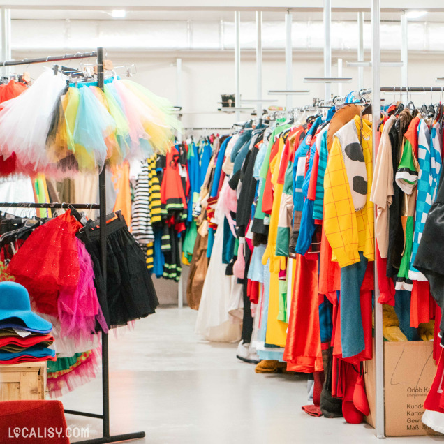 Une vue intérieure du magasin Costumes et Confettis à Waimes, présentant divers costumes et accessoires.