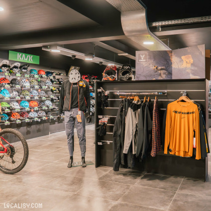 Intérieur du magasin The North Bike à Stavelot avec des vêtements et accessoires pour cyclistes.