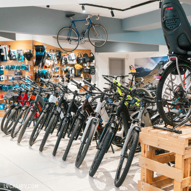 Section intérieure du magasin affichant une collection de vélos électriques et leurs accessoires, avec un décor moderne et organisé.