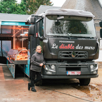 Camion de la poissonnerie Le diable des Mers à Beaufays avec une employée posant à côté.