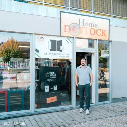 Propriétaire posant devant la façade de Home Destock à Herstal.