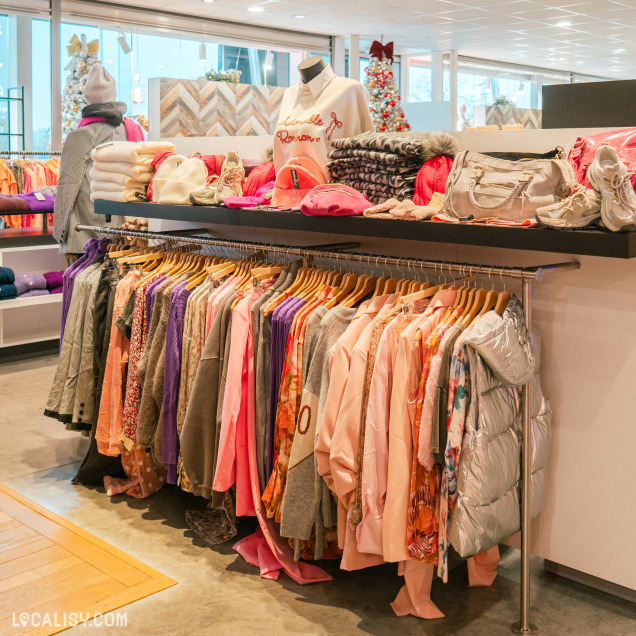 Rayons de vêtements féminins aux tons roses au magasin By Lou H à Neupré.