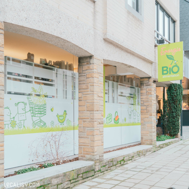 Devanture du magasin Énergie Bio à Heusy, avec des illustrations colorées et l’enseigne du magasin affichant "Énergie Bio alimentation".