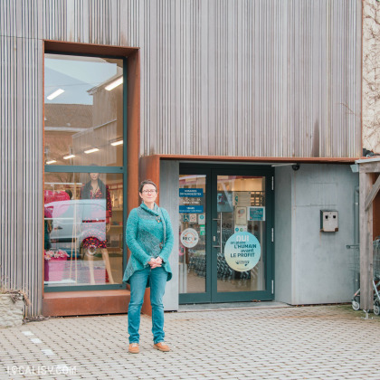 Façade du magasin de seconde main 3R second hand à Lontzen avec une employée devant l'entrée.