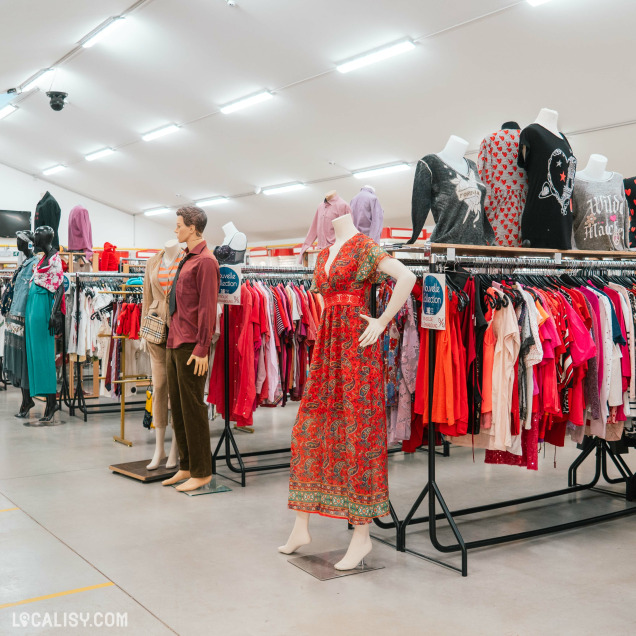 Section des vêtements colorés pour femmes et mannequins dans le magasin 3R second hand à Lontzen.