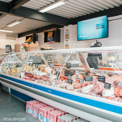 Vitrine réfrigérée de fromages et charcuteries italiennes au magasin La Maison Butera à Seraing.