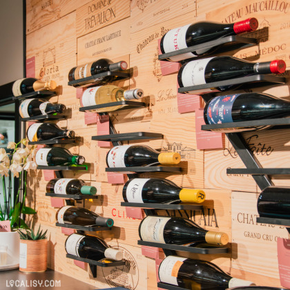 Présentation élégante de bouteilles de vin à la fromagerie La Cave d'Axelle à Theux.