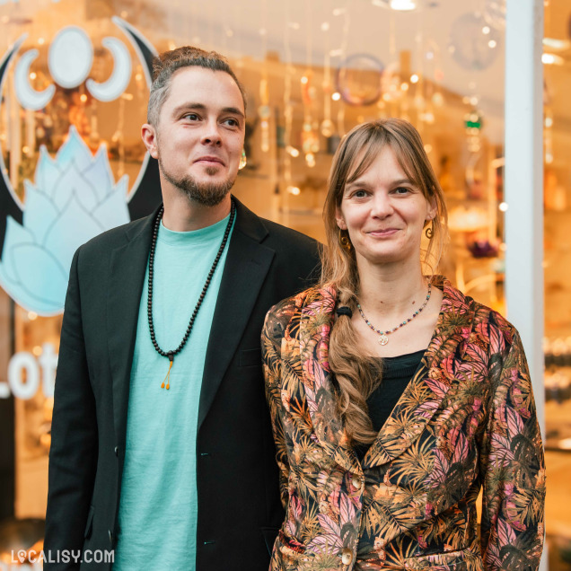 Deux gérants du magasin d'articles spirituels Le Lotus Bleu à Malmedy devant leur boutique.