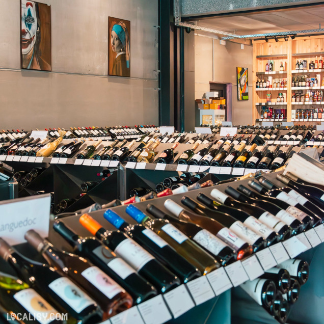 Rayon de vins : Présentation soignée de bouteilles de vin dans La Boîte à Pinards à Nandrin, une cave réputée pour sa diversité de crus.